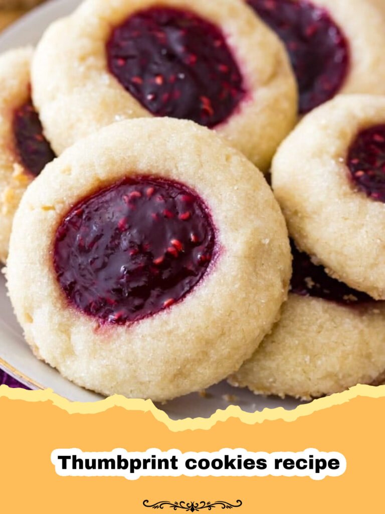 A plate of freshly baked classic jam thumbprint cookies with raspberry and apricot fillings.