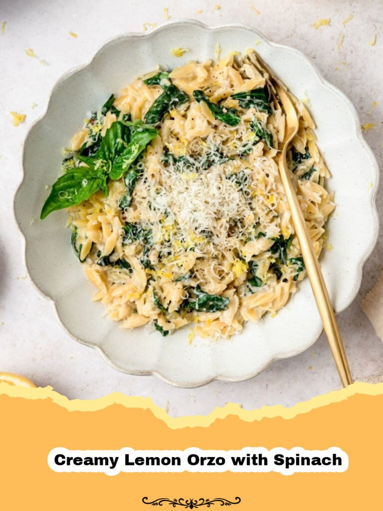 A close-up shot of a bowl of creamy lemon orzo with vibrant green spinach, garnished with fresh herbs.