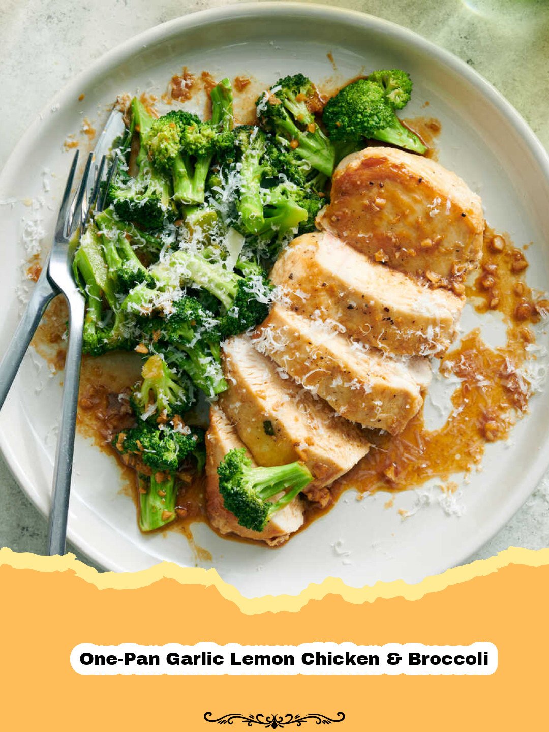 A close-up shot of golden-brown One-Pan Garlic Lemon Chicken & Broccoli on a baking sheet, garnished with fresh lemon slices and parsley.