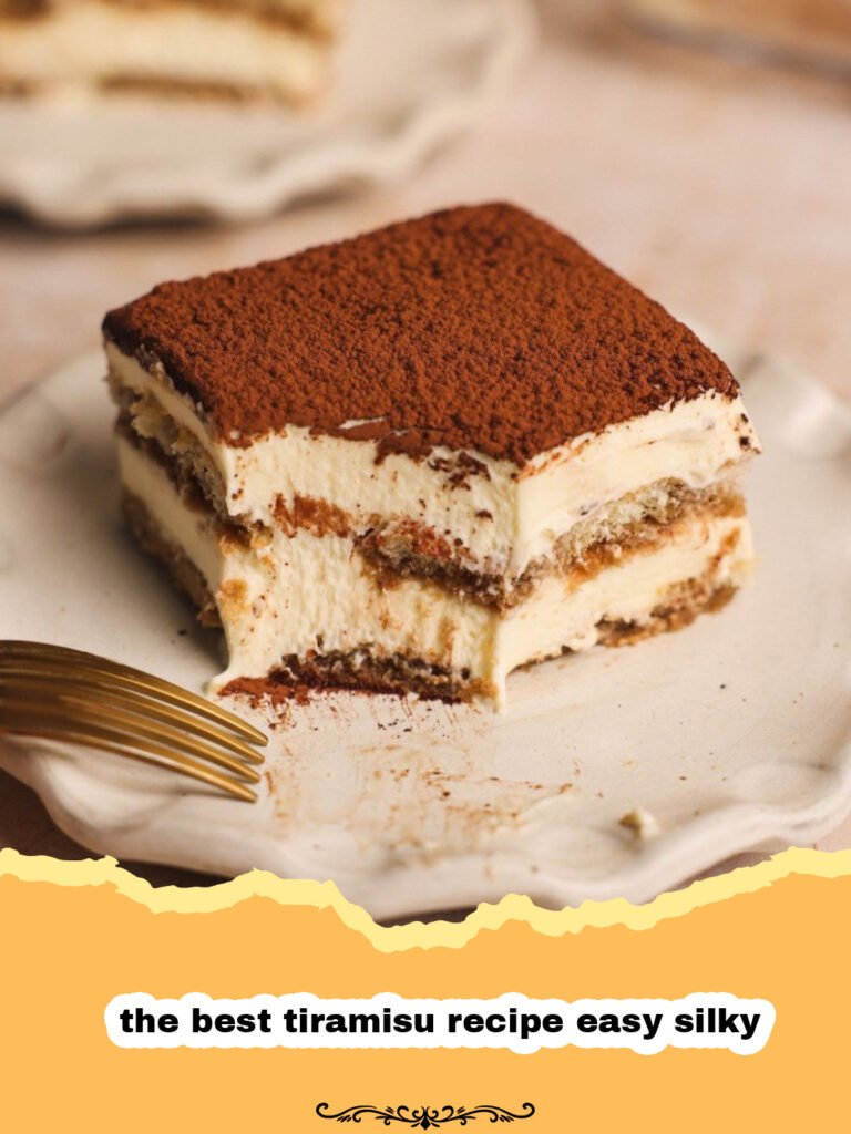 A perfectly set, silky smooth Tiramisu dusted with cocoa powder, showing distinct layers of cream and coffee-soaked ladyfingers.