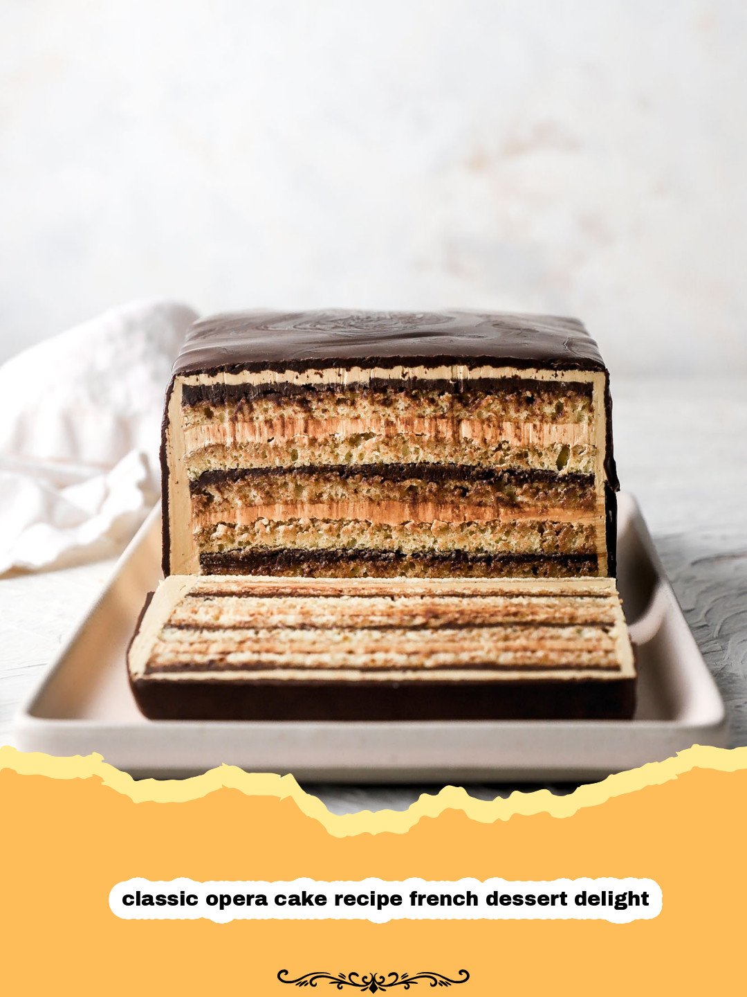 Mastering the Classic Opera Cake: Your Guide to a French Dessert Delight 3 A perfectly sliced classic opera cake showing its distinct layers of almond sponge, coffee buttercream, and chocolate ganache, topped with a glossy chocolate glaze and a delicate chocolate decoration.