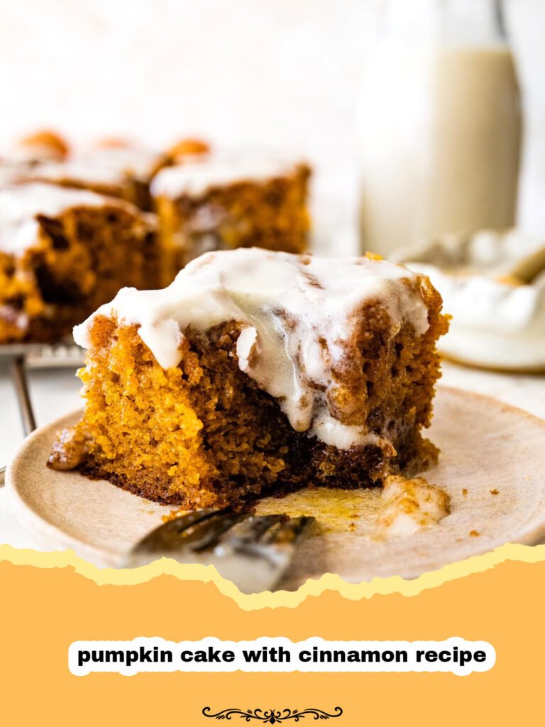 The Ultimate Moist & Spiced Pumpkin Cake with Cinnamon Cream Cheese Frosting 5 Slice of moist pumpkin cake with cinnamon cream cheese frosting on a white plate, garnished with a sprinkle of cinnamon.
