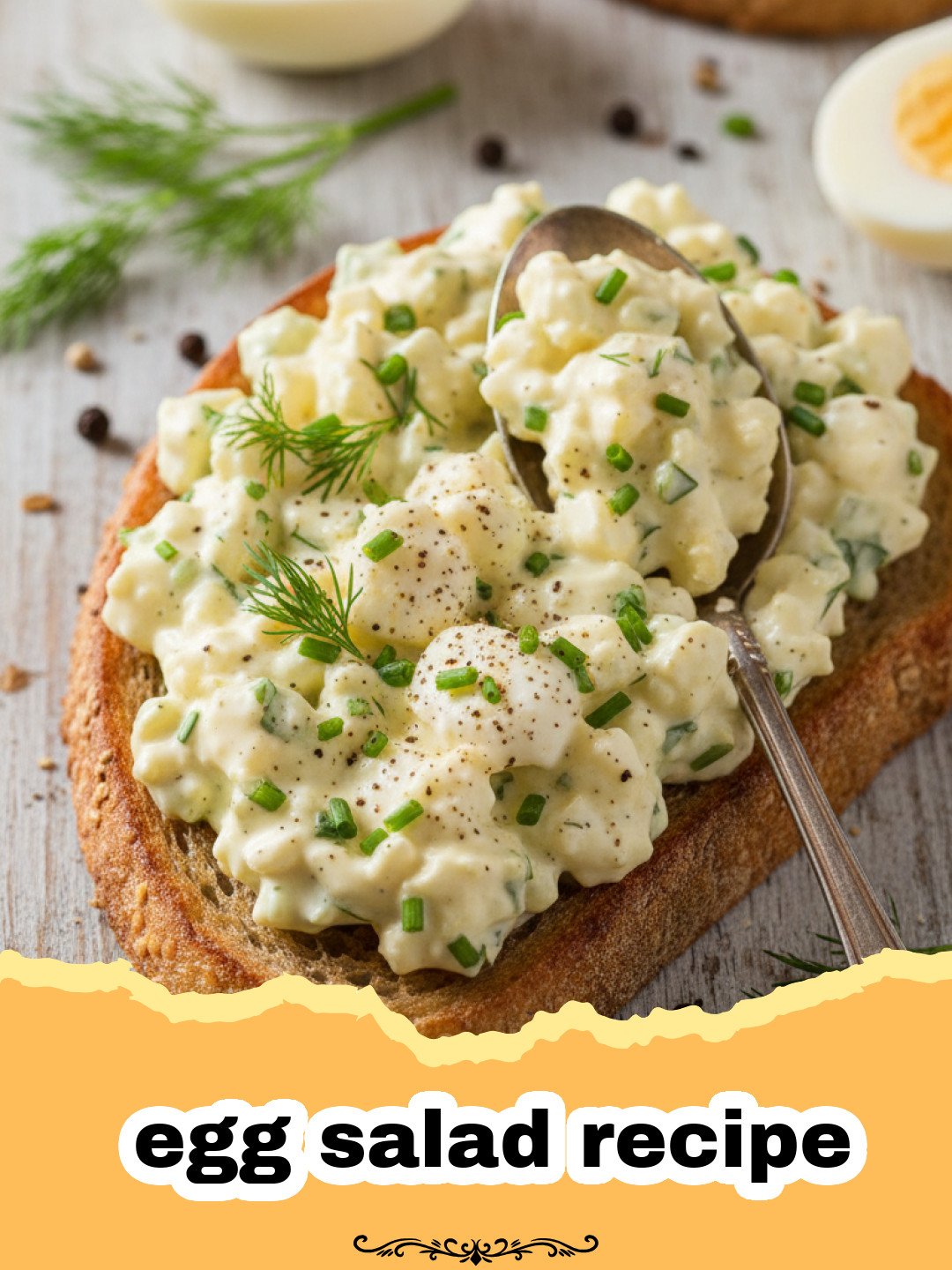 egg salad recipe - A creamy, classic egg salad in a bowl with fresh dill, served with toasted bread slices.