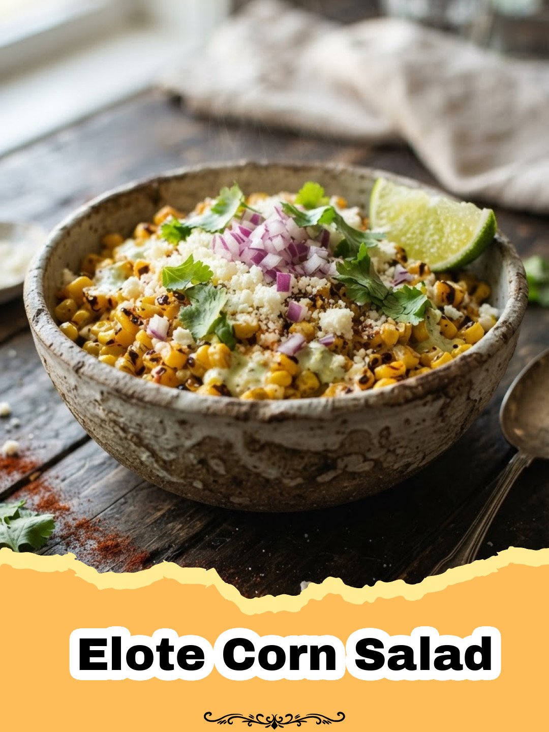 Creamy Elote Corn Salad in a serving bowl, garnished with cilantro and chili powder, with lime wedges on the side.