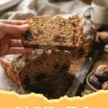 Date Nut Bread Recipe - A moist slice of Date Nut Bread with walnuts and dates on a plate with a cup of coffee.
