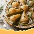 Pear and Pistachio Cream Tart with Linzer Pastry Crust - Close-up of a beautifully baked Pear and Pistachio Cream Tart with a decorative Linzer pastry crust, dusted with powdered sugar, sitting on a wooden board.