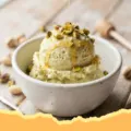 Close-up of creamy green Pistachio Cottage Cheese Ice Cream in a bowl with chopped pistachios on top.