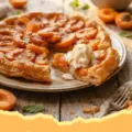 Golden brown Puff Pastry Apricot Glazed Tart with glossy apricots, served on a white plate.